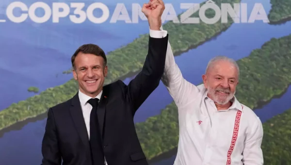Президент Бразилии Луис Инасиу Лула да Силва (справа) и президент Франции Эмманюэль Макрон позируют для фотографов после встречи в рамках 30-й конференции ООН по изменению климата (COP30) в Белене, Бразилия.